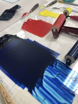 3 colours of ink blue, red and yellow rolled out with rollers